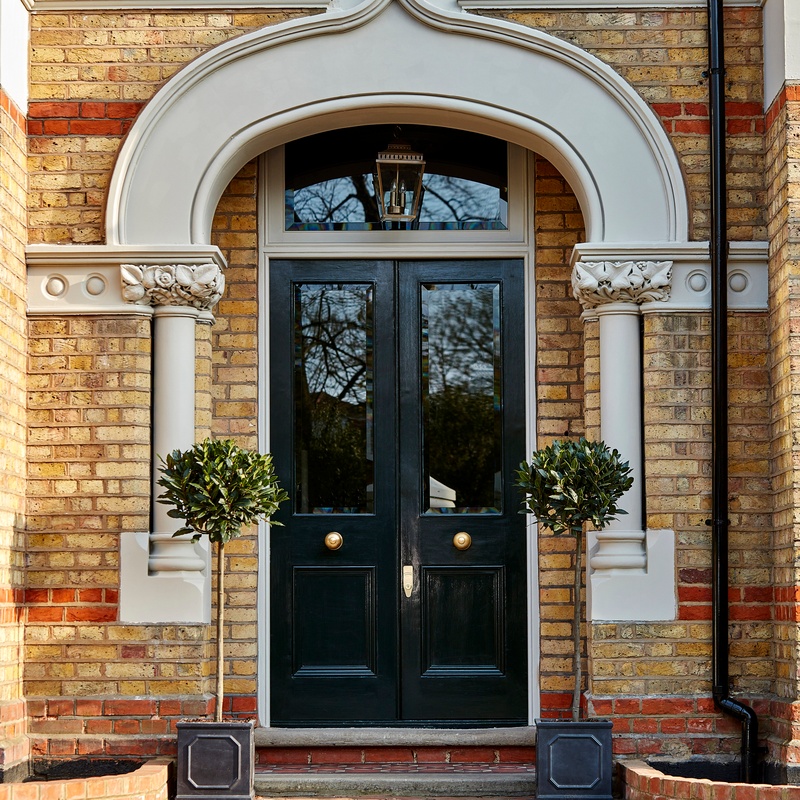 Black door entrance to brick house
